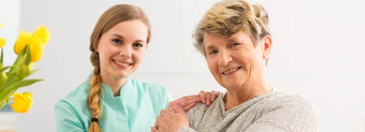 old woman and a caregiver holding their hands