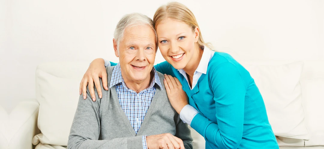 caregiver embracing an old man