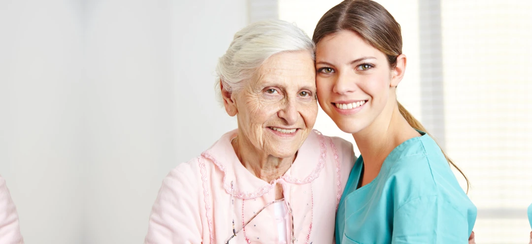 Caregiver embracing happy senior