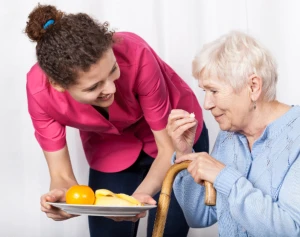 caregiver giving food to the old woman